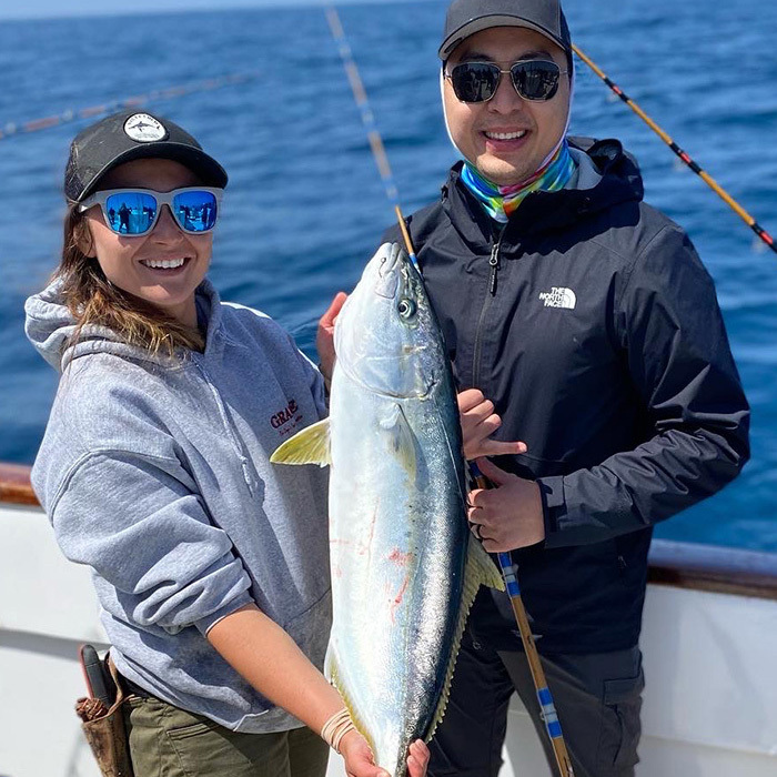 two fishermen show off their catch